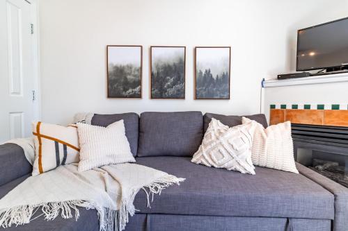 a living room with a gray couch with pillows at Alpenglow Lodge by Elevate Vacations in Whistler