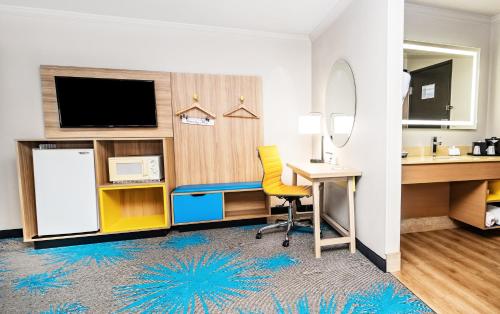 a hotel room with a desk and a tv at Days Inn by Wyndham Fort Smith in Fort Smith