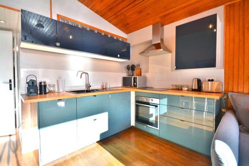 Il comprend une cuisine avec des placards bleus et une télévision à écran plat. dans l'établissement Appartement avec vue, 2 chambres, 6 pers, Morzine, à Morzine