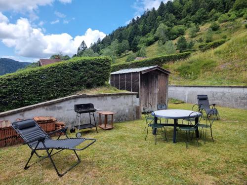 un groupe de chaises et de tables dans une cour dans l'établissement Le 