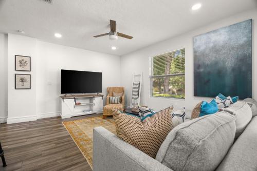 a living room with a couch and a flat screen tv at NEW! SoHo Oasis - Incredible Home In Heart of SoHo District in Tampa