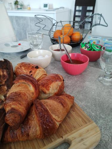 - une table avec des croissants et du pain sur une planche de découpe dans l'établissement Chambres chez l'habitant proche sortie A10, à Pons