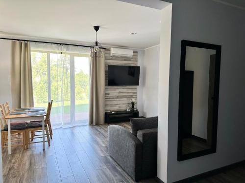 a living room with a couch and a table and a television at Apartamenti Zaķi in Saulkrasti