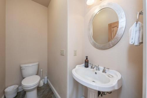 a bathroom with a sink and a toilet and a mirror at Sunset Mountain Hot Tub, Fire Table, Epic Views in Shaver Lake