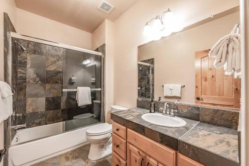 a bathroom with a sink and a toilet and a shower at Sunset Mountain Hot Tub, Fire Table, Epic Views in Shaver Lake