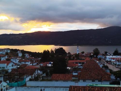 a view of a city with a sunset in the background at Hotel El Dorado Guatavita in Guatavita