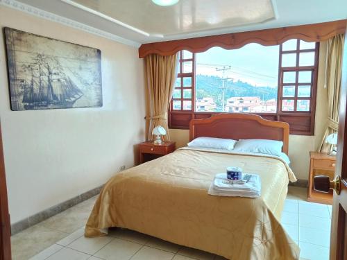 瓜塔维塔Hotel El Dorado Guatavita的一间带床和大窗户的卧室