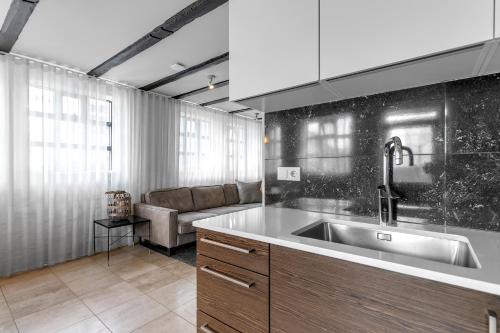une cuisine avec un évier et un canapé dans l'établissement Heart of Reykjavik - Luxury Apartments, à Reykjavik