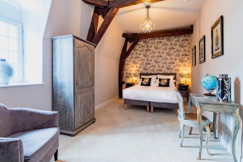 a bedroom with a bed and a table and a chair at Hôtel de la Poste à Avallon, Bourgogne in Avallon