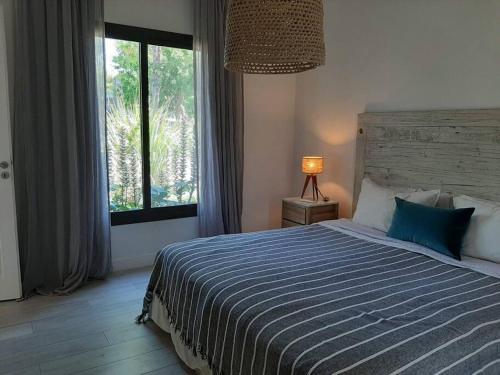 a bedroom with a large bed and a window at Casa en El lucero, Pilar in Manuel Alberti