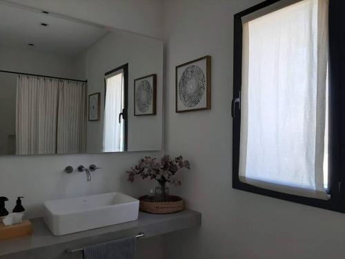 a bathroom with a white sink and a mirror at Casa en El lucero, Pilar in Manuel Alberti