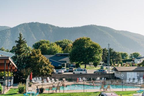 a swimming pool with a parking lot and mountains in the background at Mountain View Lodge in Chelan