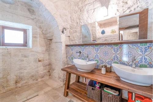 a bathroom with two sinks on a wooden table at Trullo Matilde in Martina Franca