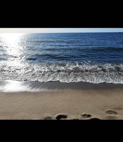 a beach with footprints in the sand and the ocean at Zefir Leśnica in Dąbki