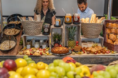 a group of people standing behind a buffet of food at Mercure Le Mans Centre in Le Mans