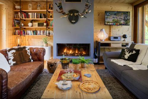 un salon avec un canapé et une cheminée dans l'établissement Le Grand Capricia - OVO Network, à La Clusaz