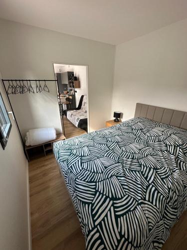 une chambre avec un lit noir et blanc et un miroir dans l'établissement Cottage bungalow le St Vel', à Velennes