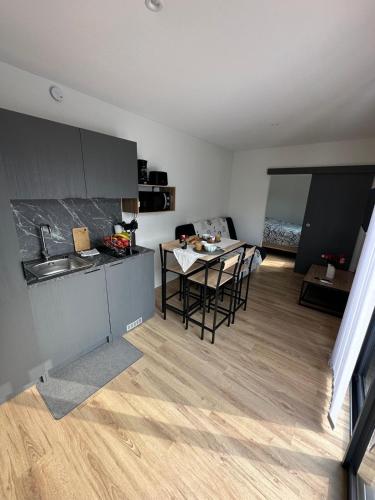 une cuisine avec une table et des chaises dans une pièce dans l'établissement Cottage bungalow le St Vel', à Velennes