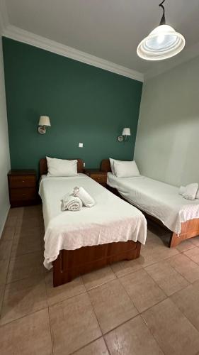 a room with two beds and a green wall at Anemos in Agia Triada