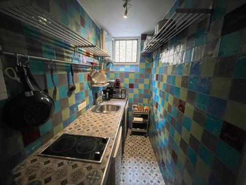 - une cuisine carrelée avec évier et cuisinière dans l'établissement Entire rental unit in Paris, à Paris