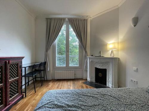 - une chambre avec une cheminée, un lit et une fenêtre dans l'établissement Entire rental unit in Paris, à Paris