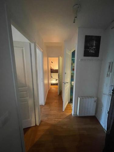 - un couloir avec des murs blancs, des portes blanches et du parquet dans l'établissement Entire rental unit in Paris, à Paris