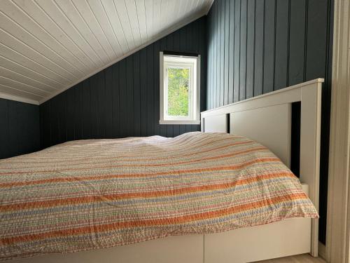 a bedroom with a bed and a window at Cosy cabin in Risør in Risør