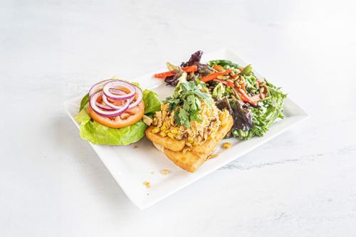 a white plate with a sandwich and a salad at Accent Inns Victoria in Victoria
