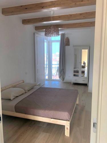 a large bed in a room with a large window at Attico Saluzzo centro 2 in Saluzzo