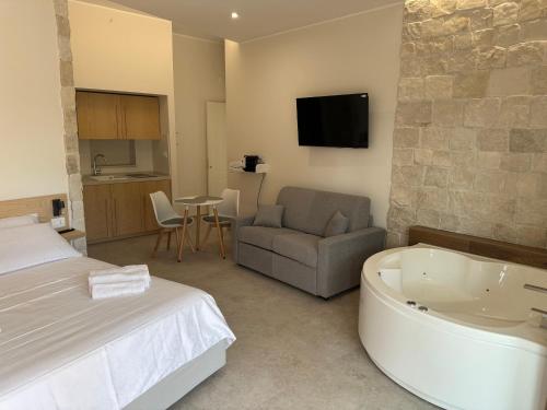 a bedroom with a bed and a tub in a room at Luna D'Argento in Leporano Marina