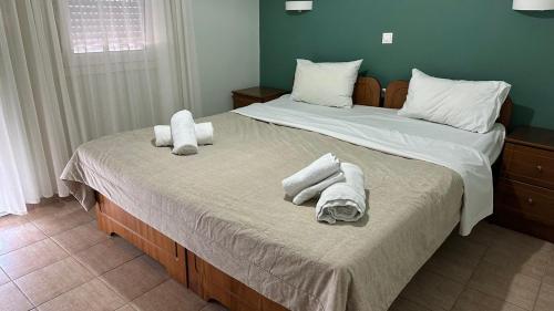 two beds with towels on them in a bedroom at Anemos in Agia Triada