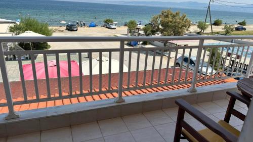 a balcony with a view of a parking lot and the ocean at Anemos in Agia Triada