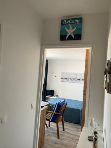 une chambre avec un lit, un bureau et une chaise dans l'établissement Aux pieds des plages, du port, de la piste cyclable et des commerces de proximité, un studio au dernier étage avec une vue panoramique sur le Bassin d'Arcachon, entièrement rénové, dans une résidence avec piscine, à Arcachon