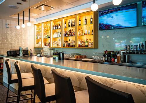a bar in a restaurant with chairs and a television at Accent Inns Burnaby in Burnaby