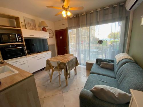 un salon avec un canapé bleu et une table dans l'établissement Appartement climatisé avec jardin, proche Thermes et commerces - FR-1-503-40, à Balaruc-les-Bains