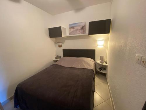 une petite chambre avec un lit et un bureau dans l'établissement Appartement climatisé avec jardin, proche Thermes et commerces - FR-1-503-40, à Balaruc-les-Bains