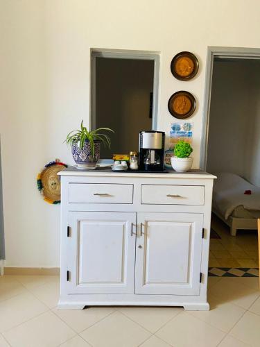 a white cabinet in a room with a mirror at Maison Mina in Oualidia
