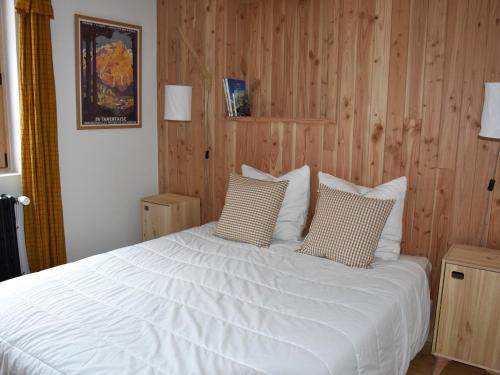 - une chambre avec un lit blanc et des murs en bois dans l'établissement Chalet ensoleillé avec balcon et poêle à bois - FR-1-464-163, à Pralognan-la-Vanoise