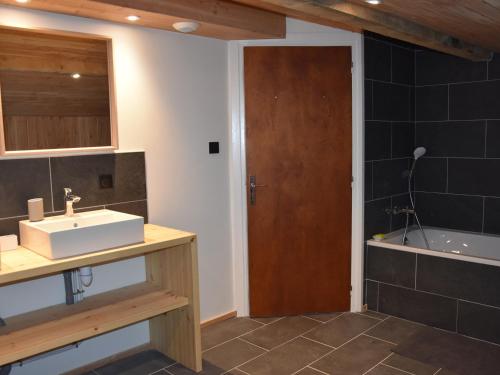 une salle de bain avec un lavabo et une baignoire dans l'établissement Chalet ensoleillé avec balcon et poêle à bois - FR-1-464-163, à Pralognan-la-Vanoise