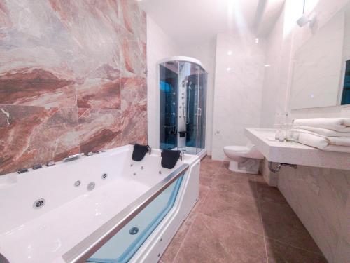 a bathroom with a tub and a sink and a toilet at Hotel Terra by Refugio Ecológico in Arequipa