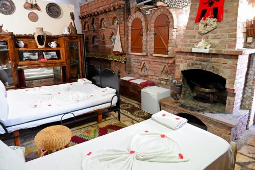 a room with two beds and a brick fireplace at Bujtina Syni Zi "Keshtjella" - Shengjin in Shëngjin