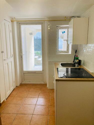 une petite cuisine avec un évier et une fenêtre dans l'établissement Flat near paris, à Épinay-sur-Seine