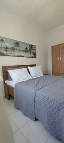 a bedroom with a bed and a picture of palm trees at White Beach Appartment in Yerakiní