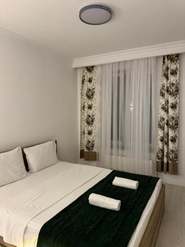 a bedroom with a bed with two towels on it at Art Apartment 2 in Prishtinë