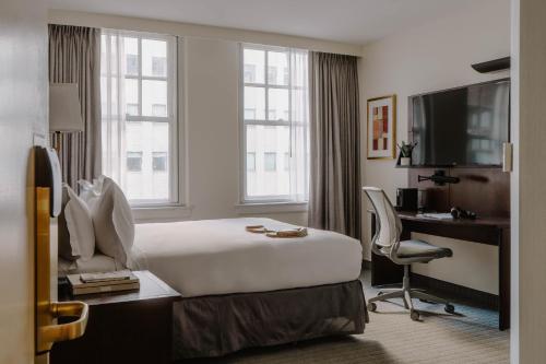 a hotel room with a bed and a desk and a computer at Club Quarters Hotel Downtown, Houston in Houston