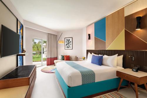 a hotel room with a bed and a tv at Secrets La Romana All-Inclusive Adult Only Resort & Spa in Bayahibe