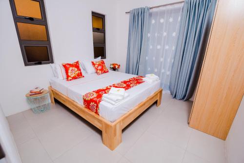 a bedroom with a bed with red pillows at L'Etoile Appartment in Flic-en-Flac