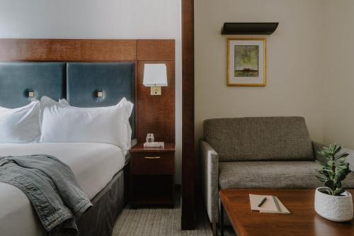 a hotel room with a bed and a chair at Club Quarters Hotel Downtown, Houston in Houston