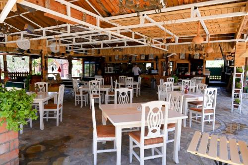 a dining room with white tables and chairs at Bujtina Syni Zi "Keshtjella" - Shengjin in Shëngjin