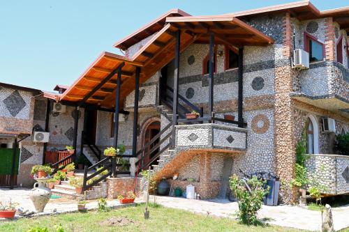 a brick house with a staircase in front of it at Bujtina Syni Zi "Keshtjella" - Shengjin in Shëngjin